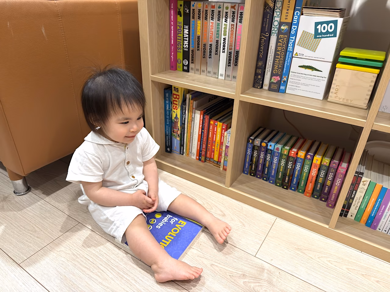 Sitting proudly with her favorite: Evolution for Babies.